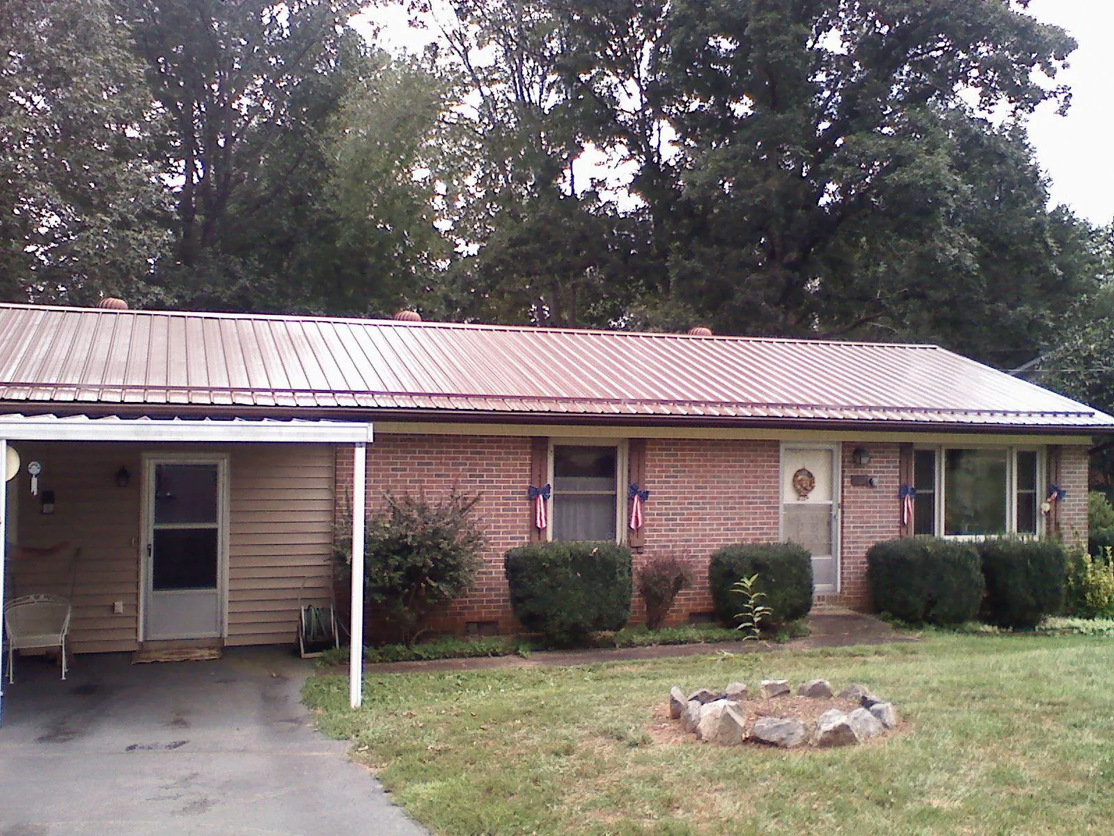 Bronze metal roof and carport on a brick ranch home — Roof Repair work by our crew in North Baltimore